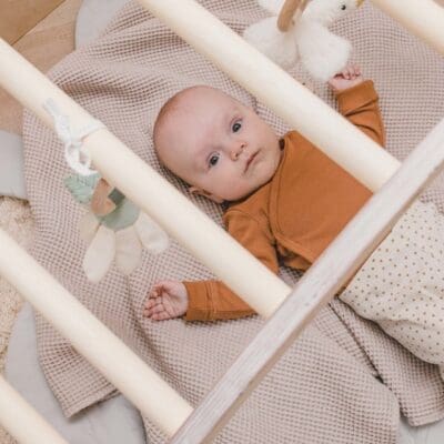 Vauva makaa LUOTO kiipeilykaaren alla sen ollessa baby mobilena käytössä